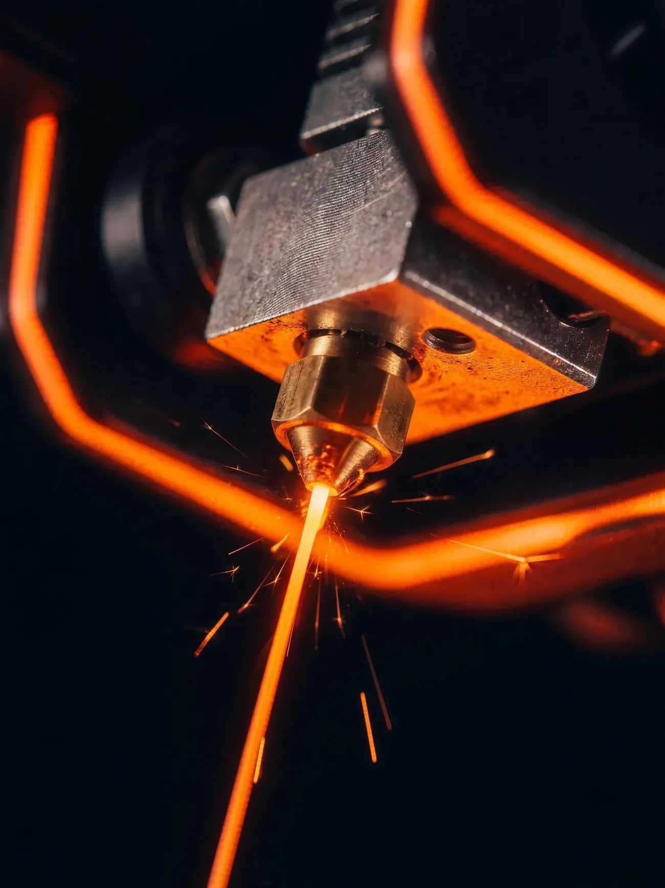 Close-up of a 3D printer hotend extruding filament